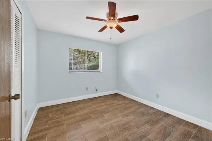 Empty room with wood finish floors and a ceiling fan