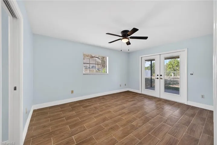 Unfurnished room with french doors, ceiling fan, and wood tiled floors