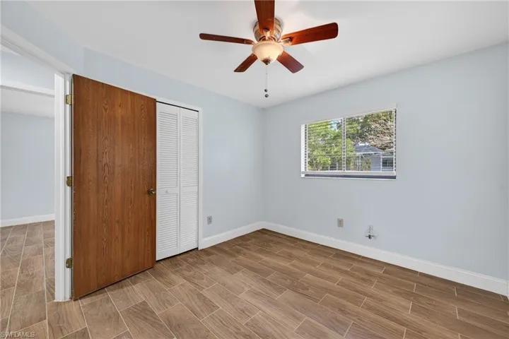 Unfurnished bedroom with wood finish floors, ceiling fan, and a closet