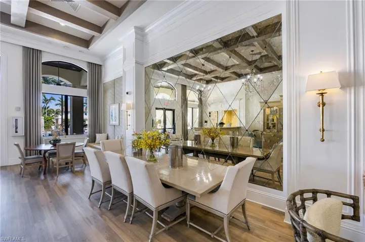 Dining room with coffered ceiling, beam ceiling, wood finished floors, and ornamental molding