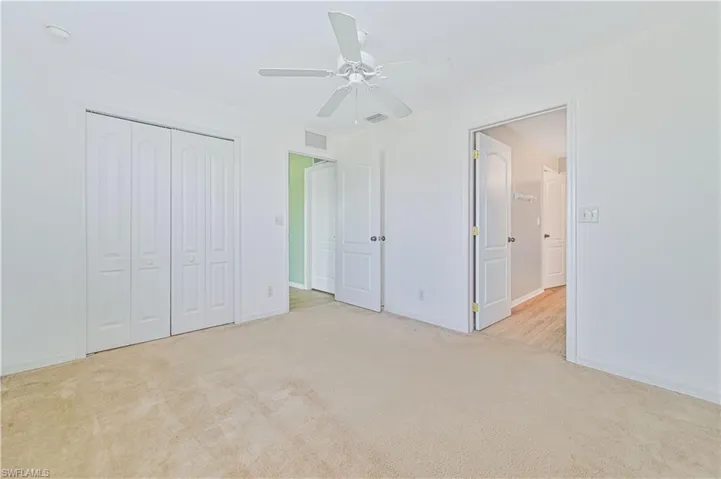 Unfurnished bedroom with light carpet, a closet, and ceiling fan