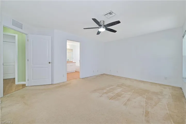 Carpeted spare room featuring ceiling fan