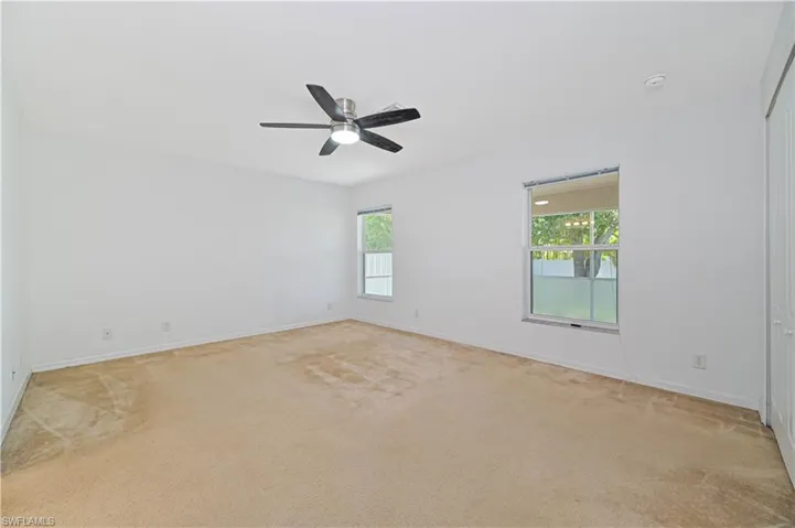 Empty room with ceiling fan and carpet floors