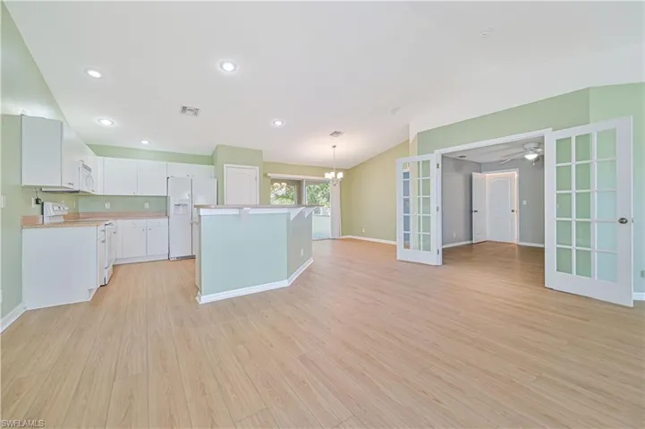Kitchen featuring a center island, white appliances, and light hardwood / wood-style flooring