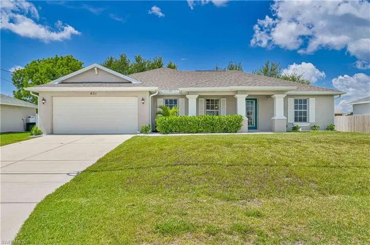 Single story home featuring a front yard and a garage