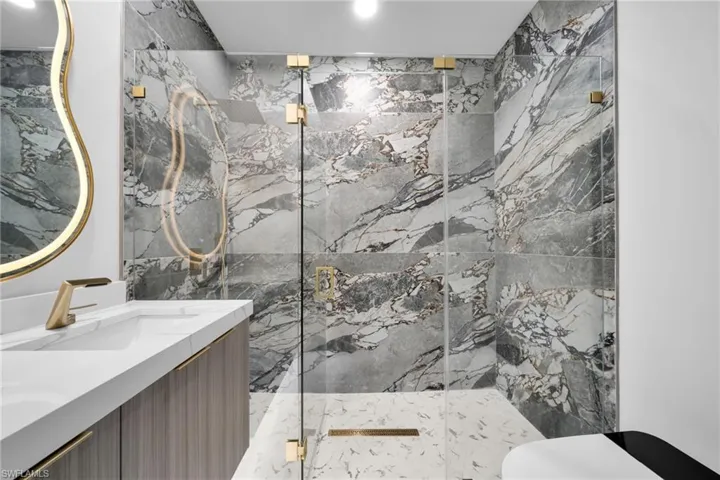 Full bathroom with vanity and a marble finish shower
