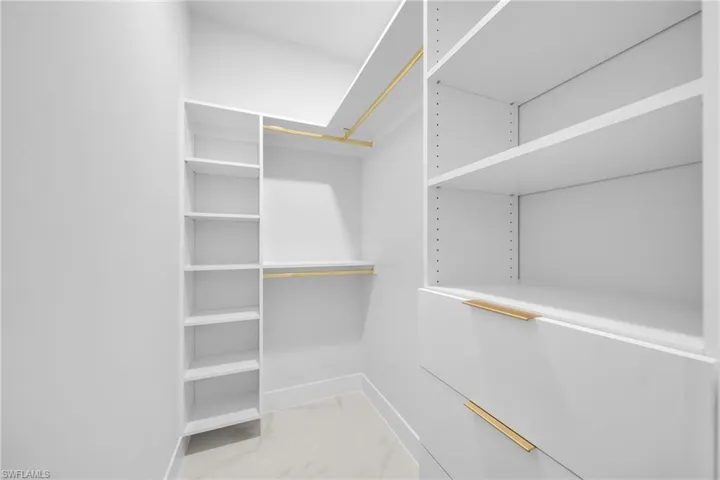 Spacious closet with light marble finish floors