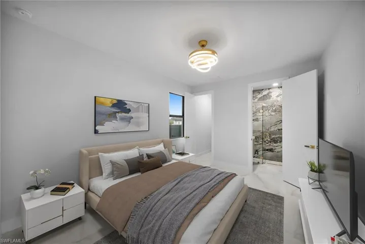 Bedroom with marble finish floors and connected bathroom