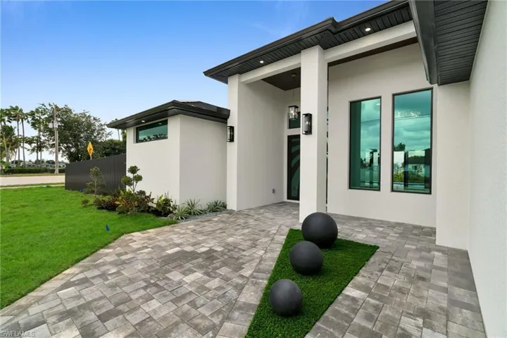 Entrance to property featuring stucco siding and a yard