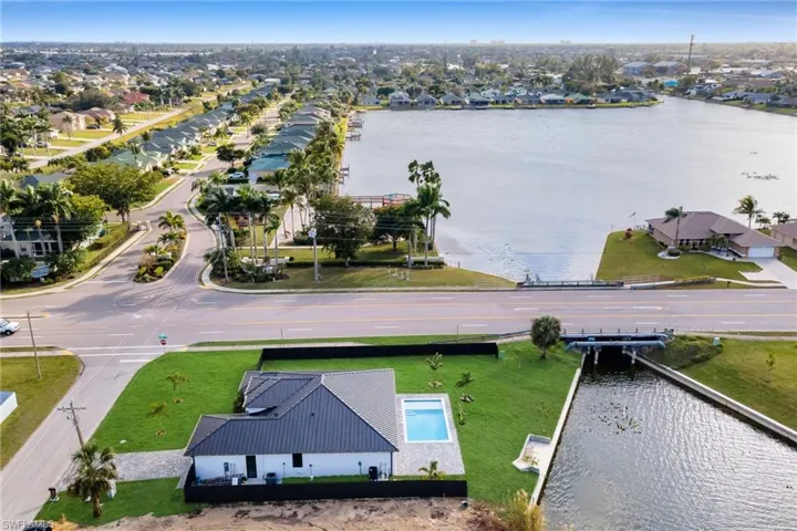 Aerial view of residential area with a large body of water and a pool