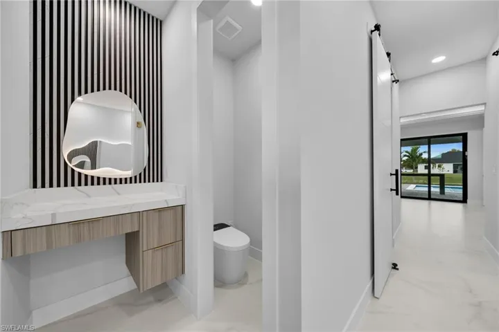 Bathroom featuring light marble finish flooring, vanity, and recessed lighting
