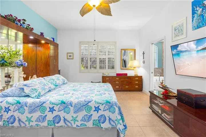 Bedroom featuring light tile patterned floors and ceiling fan