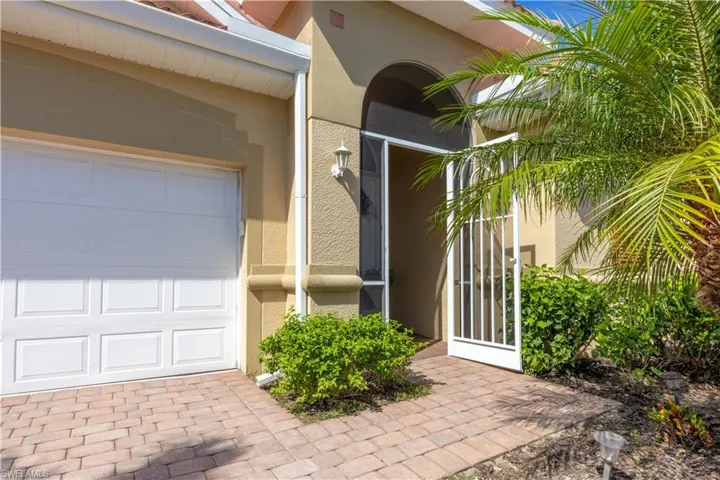 Property entrance featuring stucco siding and an attached garage
