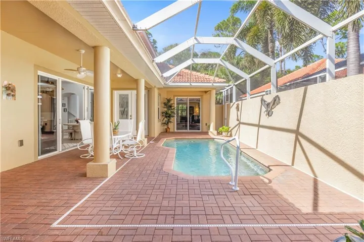View of pool featuring a patio, glass enclosure, and a ceiling fan