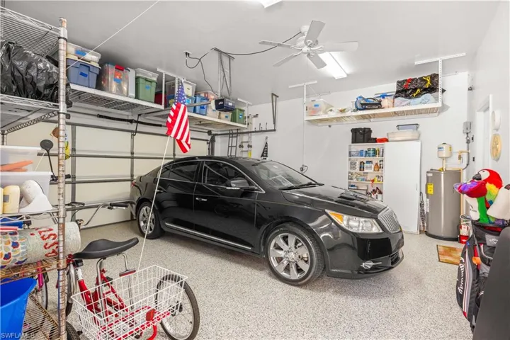 Garage with water heater, ceiling fan, and a garage door opener