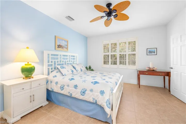 Bedroom with light tile patterned flooring, baseboards, and ceiling fan