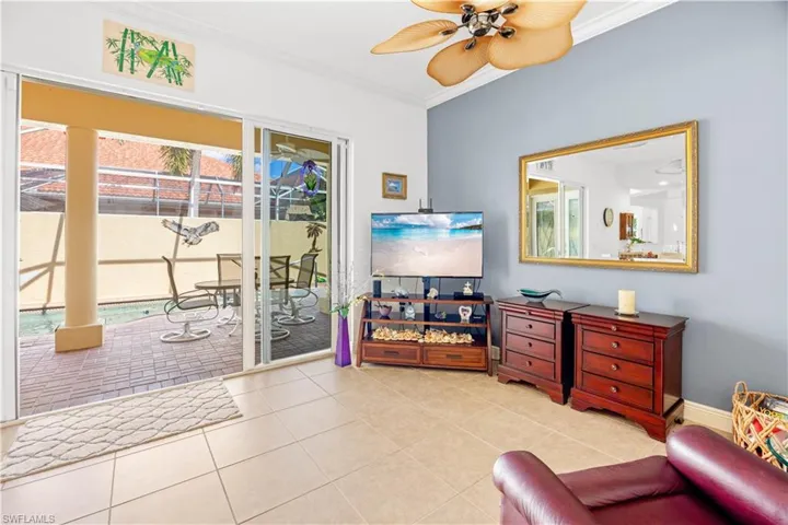 Living area with ornamental molding, ceiling fan, and tile patterned flooring