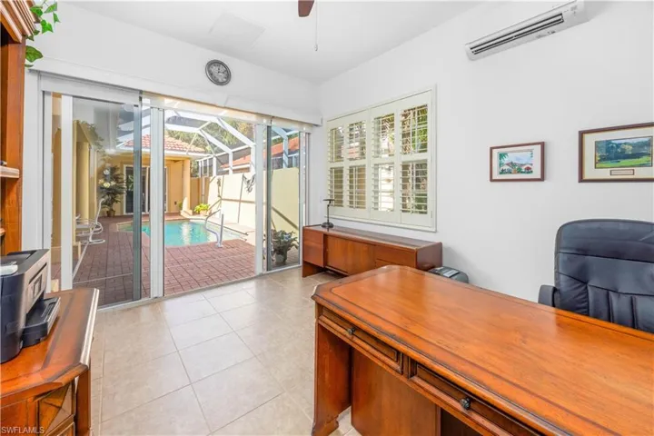 Home office featuring a wall mounted air conditioner, ceiling fan, a sunroom, and light tile patterned floors