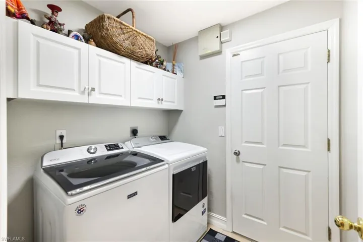 Washroom with cabinet space, baseboards, and separate washer and dryer