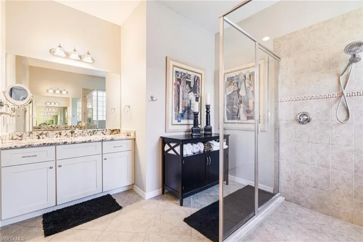 Bathroom with vanity, a shower stall, and light tile patterned flooring