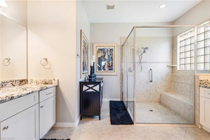 Bathroom featuring vanity, a shower stall, and light tile patterned floors