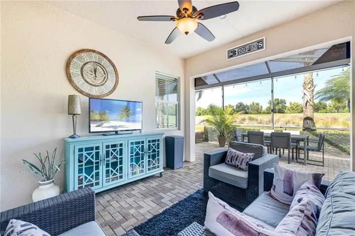 Lanai with a textured wall, ceiling fan, and brick flooring