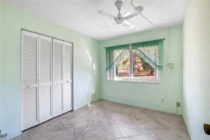 Unfurnished bedroom with a ceiling fan and a closet