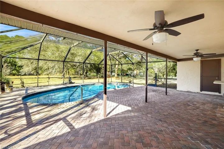 Swimming pool with a patio, a sunroom, and a lanai