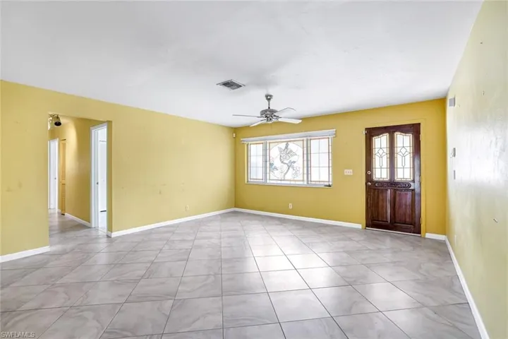 Entryway with a ceiling fan and light tile patterned floors