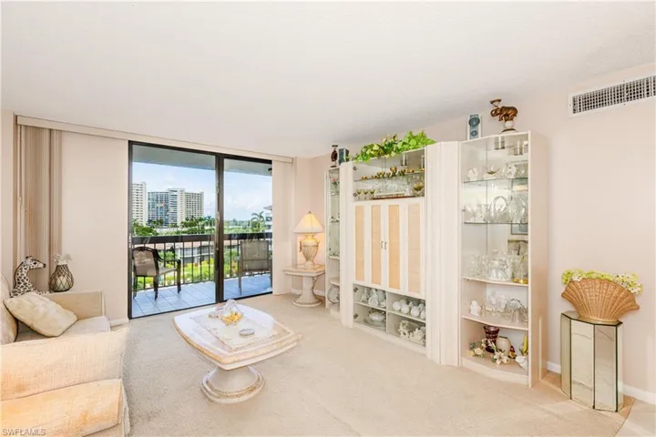 Living area with floor to ceiling windows and light colored carpet