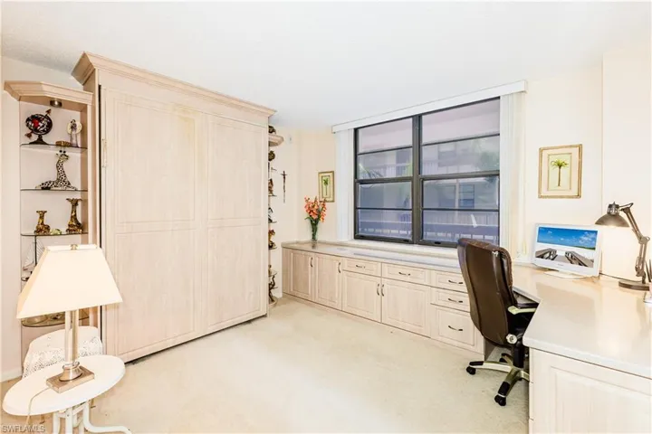 Office area featuring built in desk and light carpet