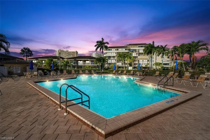 Pool at dusk featuring a patio area