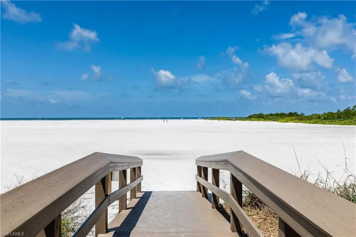View of dock with a water view and a view of the beach