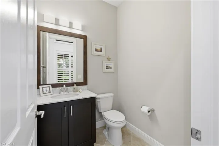Half Bath Vanity with dark wood cabinetry, light-toned countertop, and undermount sink