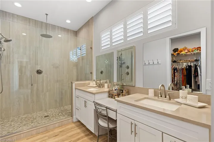 dual vanities and a shower with multiple heads