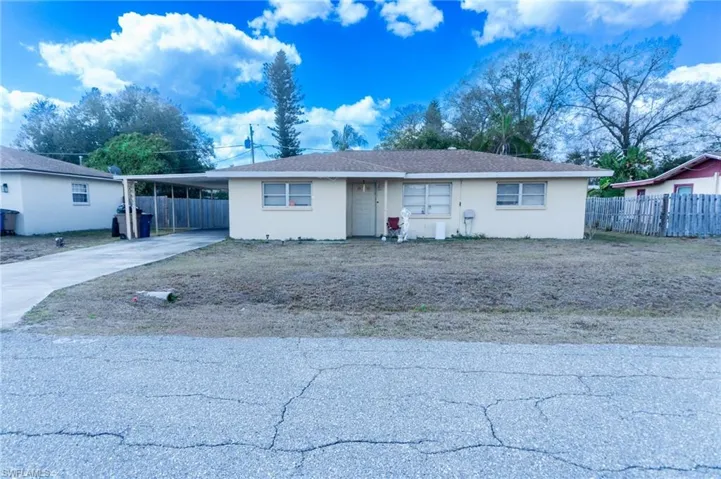 Ranch-style home with an attached carport, concrete driveway, and stucco siding