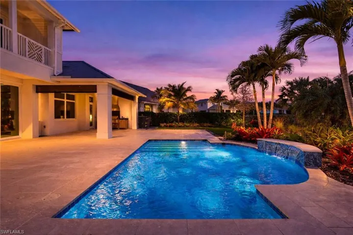 Pool at dusk with a patio and a balcony