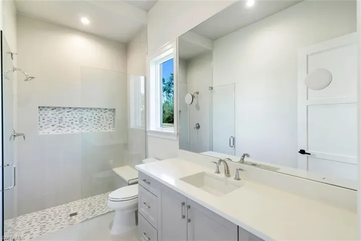 Full bathroom with a shower stall, vanity, and recessed lighting
