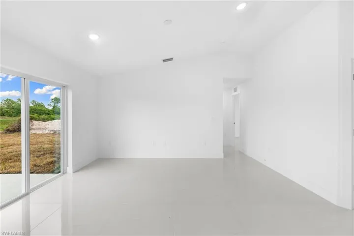 Spare room with vaulted ceiling, recessed lighting, light tile patterned flooring, and baseboards