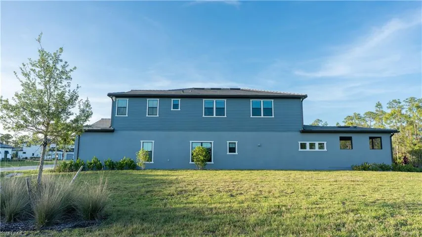 Back of property featuring a lawn and stucco siding