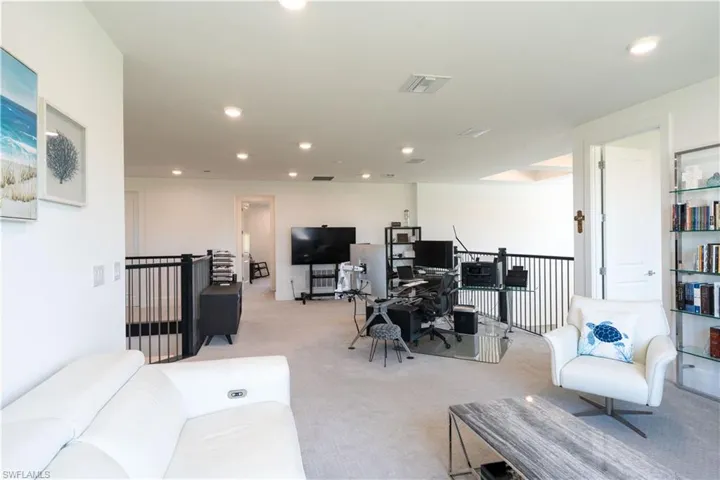 Living room with light carpet, visible vents, and recessed lighting