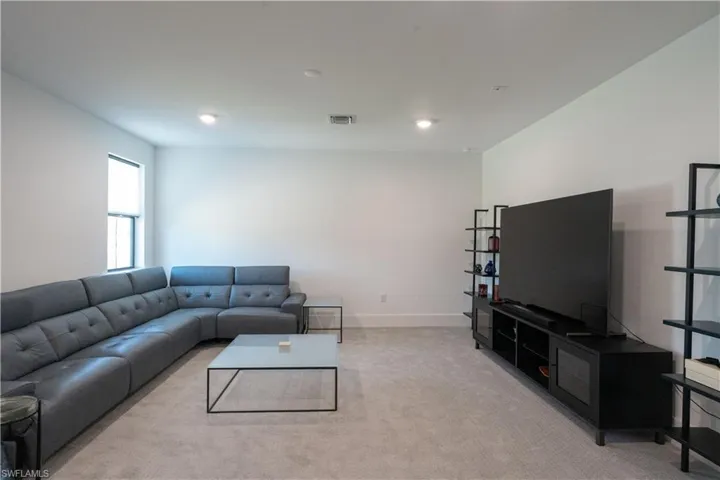Living room with baseboards, recessed lighting, light carpet, and visible vents