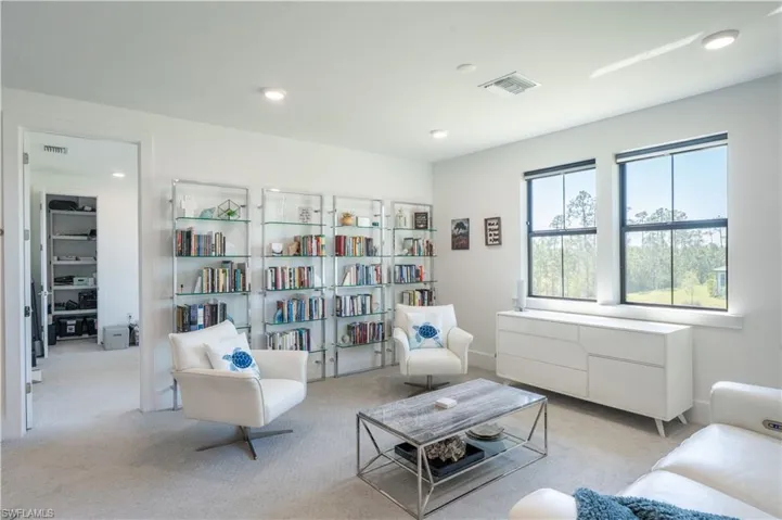 Living area with recessed lighting, visible vents, and light colored carpet