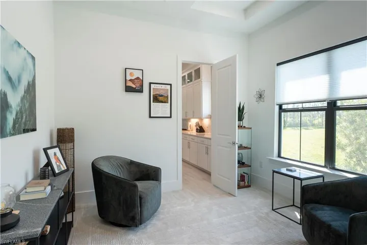 Sitting room featuring baseboards and light carpet