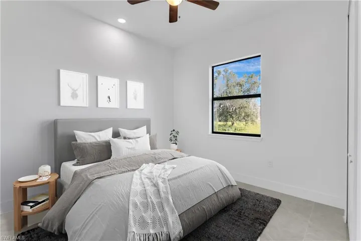 Bedroom with ceiling fan and light tile patterned floors