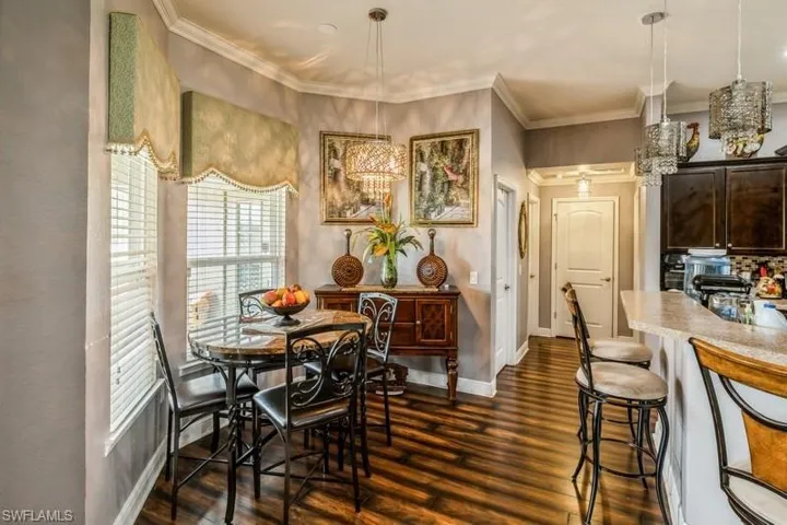 Dining space featuring dark wood-style floors and ornamental molding