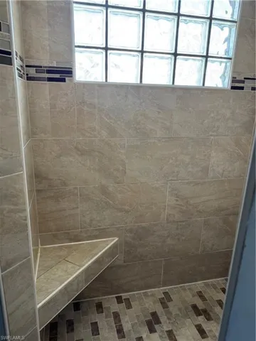 Walk in shower with bench seat in primary bathroom