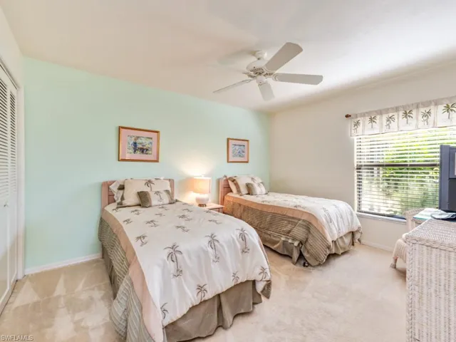 Bedroom with light colored carpet, a closet, and ceiling fan