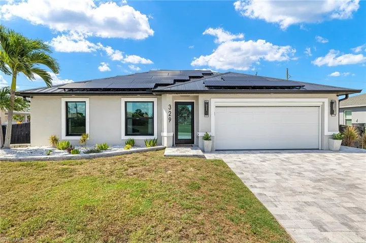 View of front of house featuring stucco siding, a standing seam roof, a garage, decorative driveway, and a metal roof