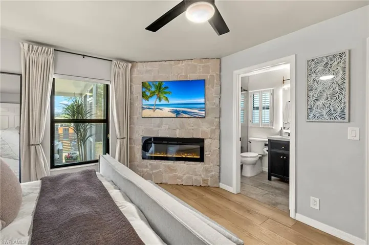 Living area featuring ceiling fan, wood finished floors, and a fireplace